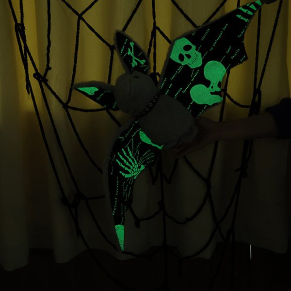 Luminous Bat Plushie - Glow in the dark: The plushie is shown being held and glowing in the dark from a side view